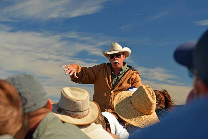 The Slow Food DFW tour group listens from their straw-bale seats as rancher Jon Taggart...