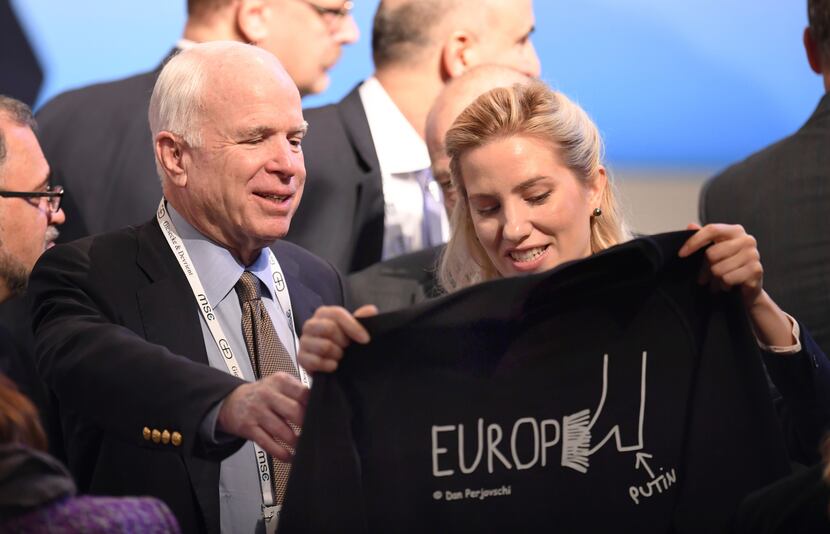 U.S. Senator John McCain, left, smiles as he gets a t-shirt by Ukrainian journalist and...