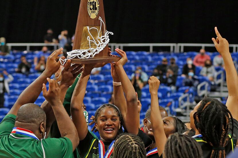 DeSoto's Ayanna Thompson holds up the state championship trophy after a 53-37 win over...