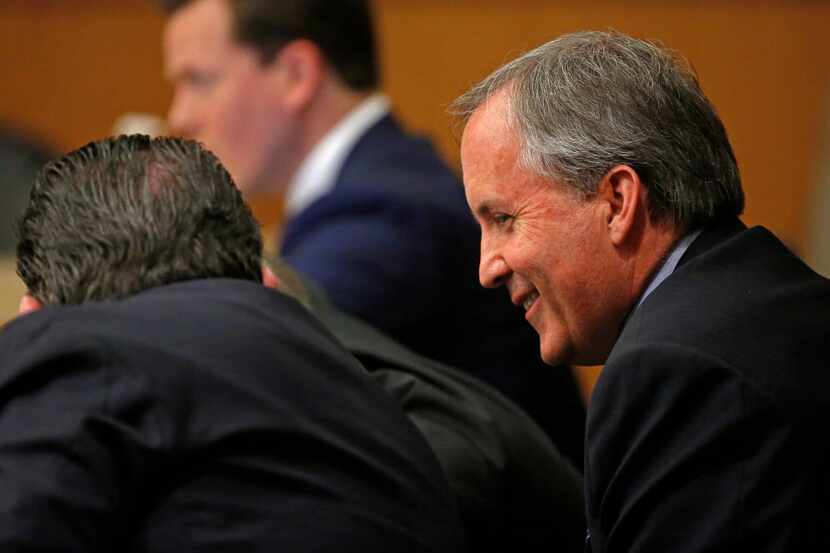Texas Attorney General Ken Paxton (right) smiles during his pretrial hearing at Collin...