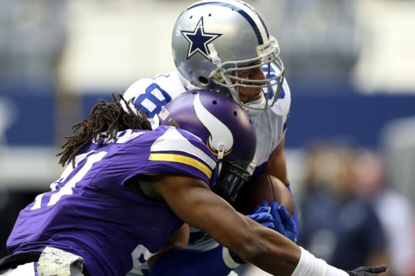 Dallas Cowboys tight end Jason Witten (82) takes a hit from Minnesota Vikings strong safety...