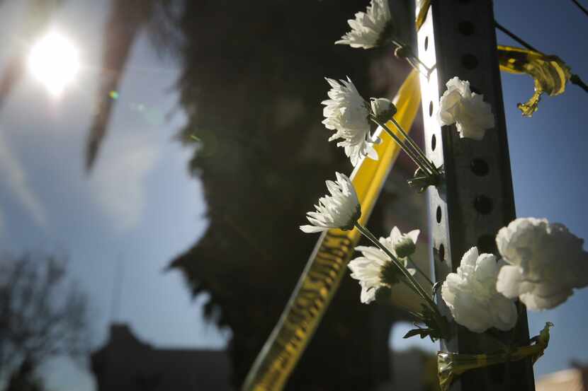 OAKLAND, CA - DECEMBER 03: Flowers are placed on a post outside a police line following an...