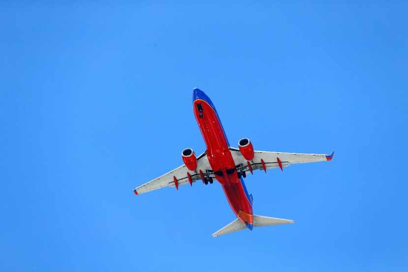 A Southwest Airlines jet makes its approach to Dallas Love Field as it passes over...