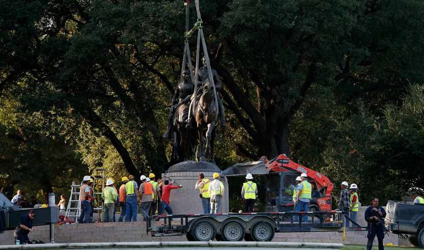 Crew members worked to remove the Robert E. Lee statue at the now-former Lee Park in Dallas...