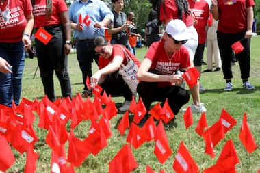 Red flags representing victims of gun violence are placed in the ground following an event...