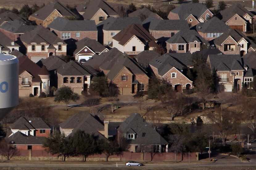  An aerial view of a Frisco water tower rising over new housing spreading out to the north...