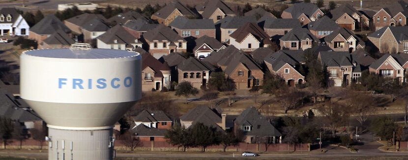  An aerial view of a Frisco water tower rising over new housing spreading out to the north...