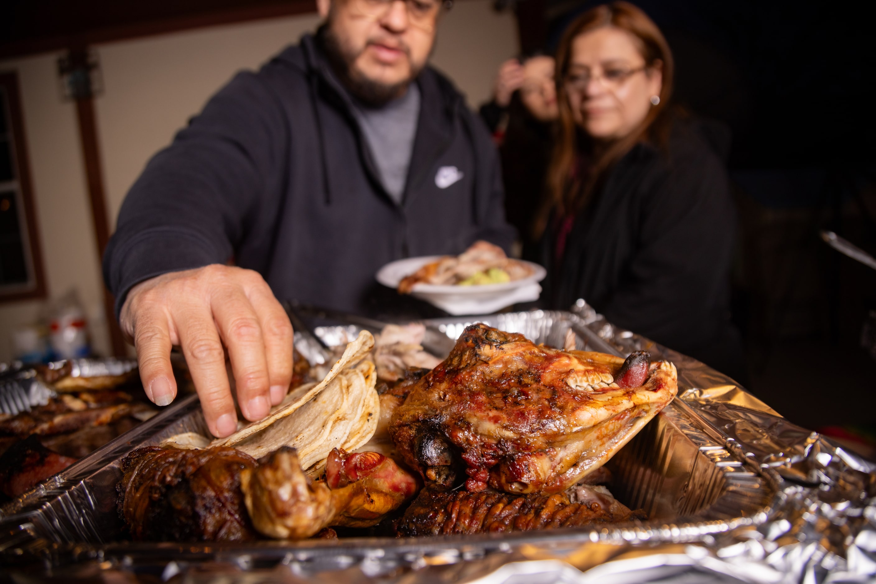 The head of the cabrito is seen as guests make their plates during a carne asada.