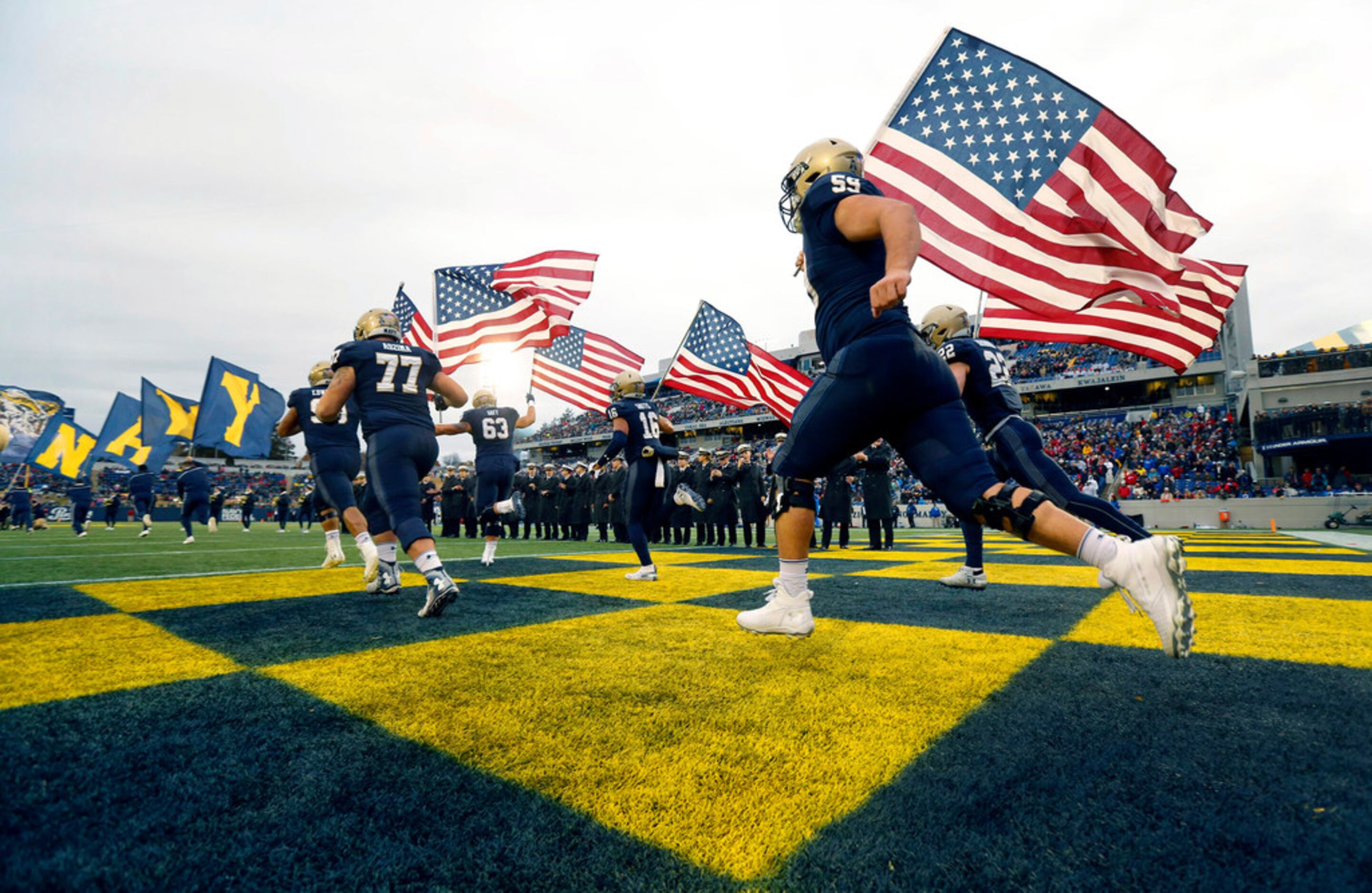 The Navy Midshipmen take the field with U.S. Flags on Senior Day at Navy-Marine Corps...