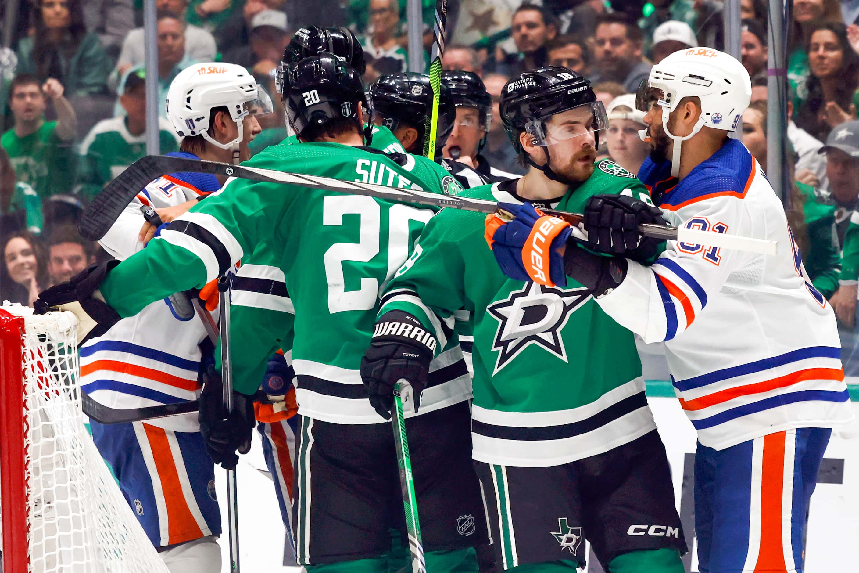Members of the Dallas Stars and Edmonton Oilers tussle after a collision involving...