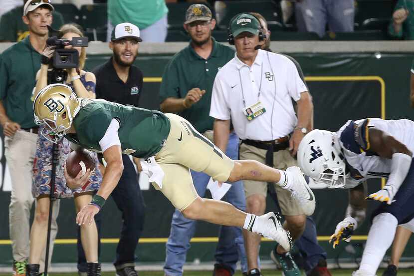 Baylor quart back Charlie Brewer (12) is forced out of bounds by West Virginia linebacker...