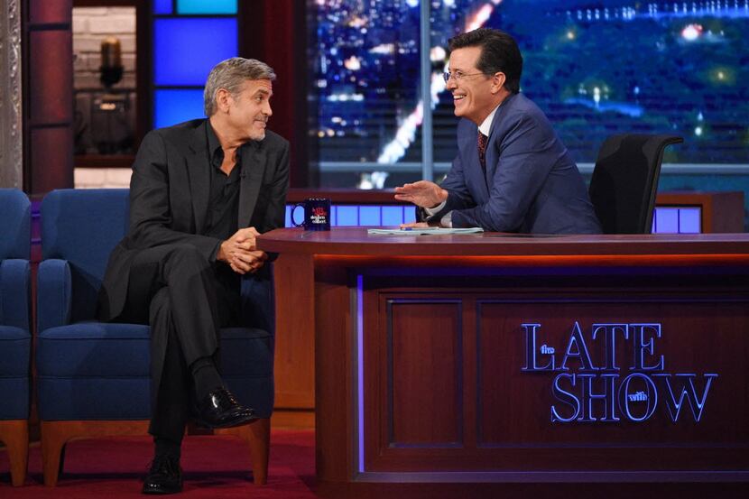 Stephen Colbert talks with actor George Clooney during the premiere episode of "The Late...