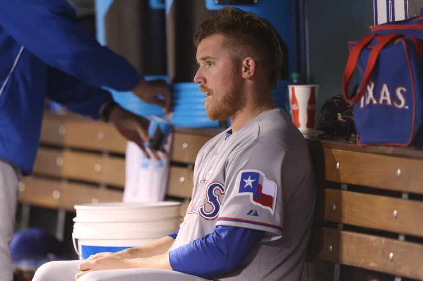Texas Rangers starting pitcher Robbie Ross, Jr., sits in the dugout after being removed from...