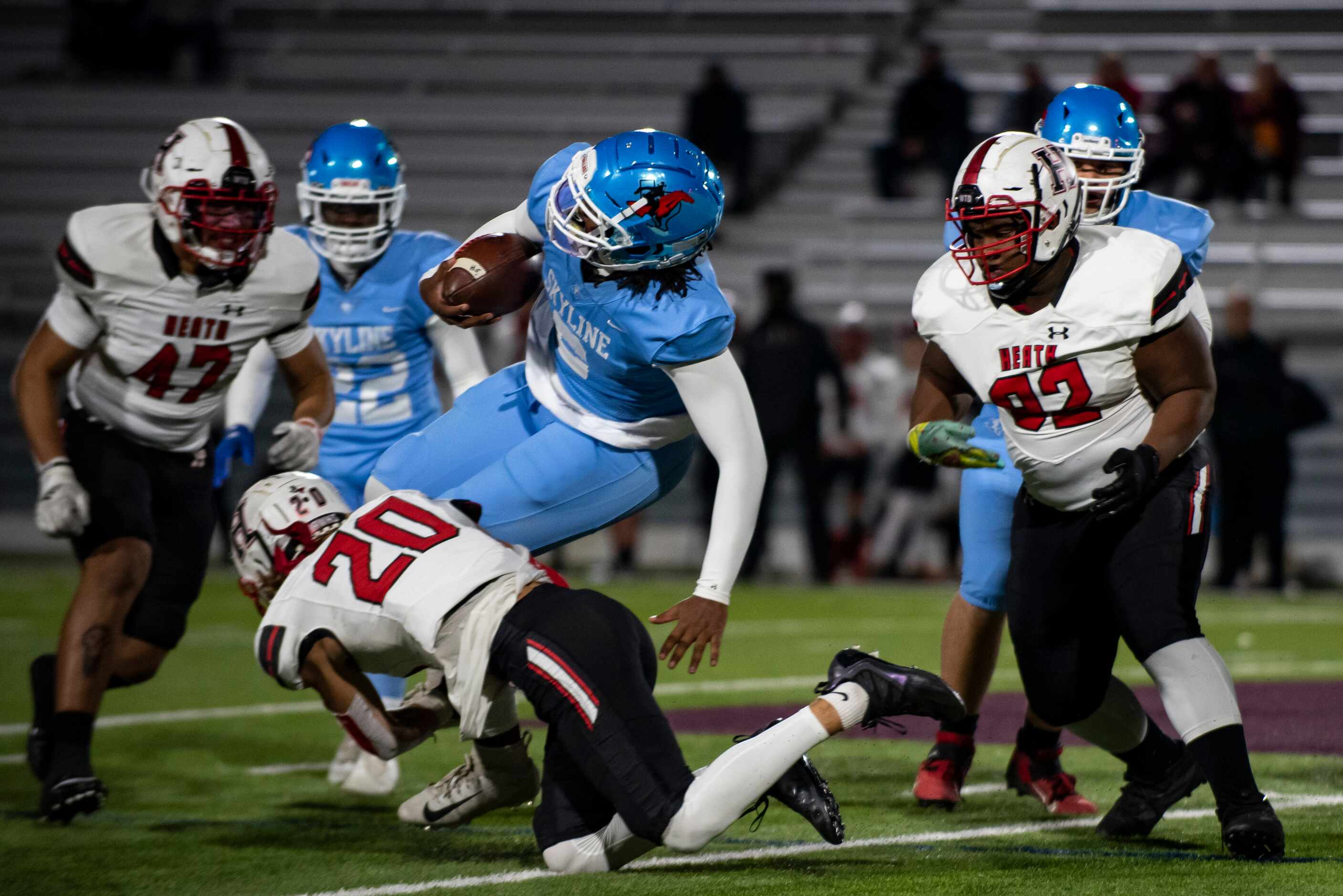 Skyline senior Darryl Richardson (2) is tackled by Heath senior Layne Horak (20) during a...