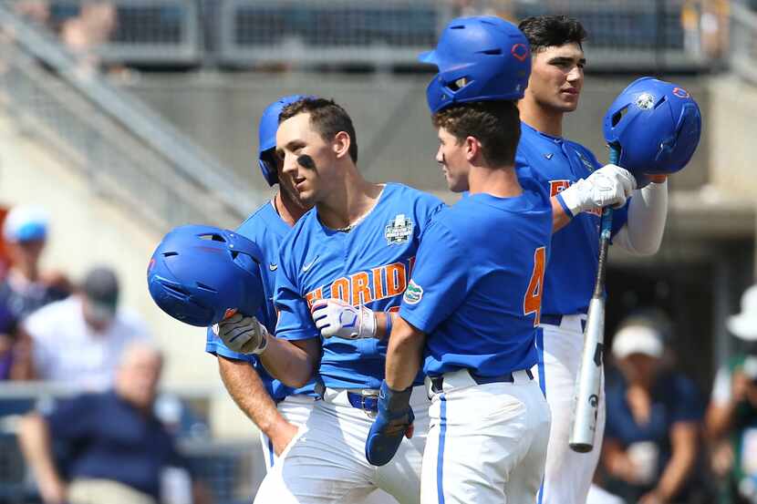 Florida's Wyatt Langford is greeted at the plate after his three-run homer during the sixth...
