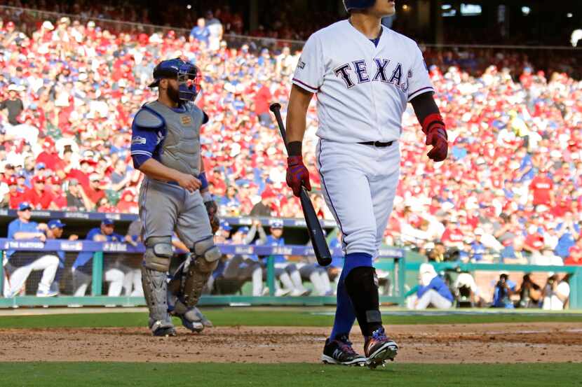 Texas Rangers right fielder Shin-Soo Choo (17) walks back to the Rangers dugout after being...