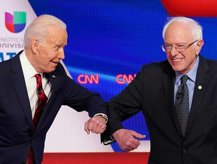 In this March 15, 2020, photo, Democrats Joe Biden and Sen. Bernie Sanders greet each other...