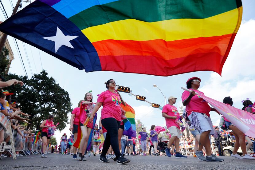 People marching with the Mobilize for Equality group pass by the Texas rainbow flag during...