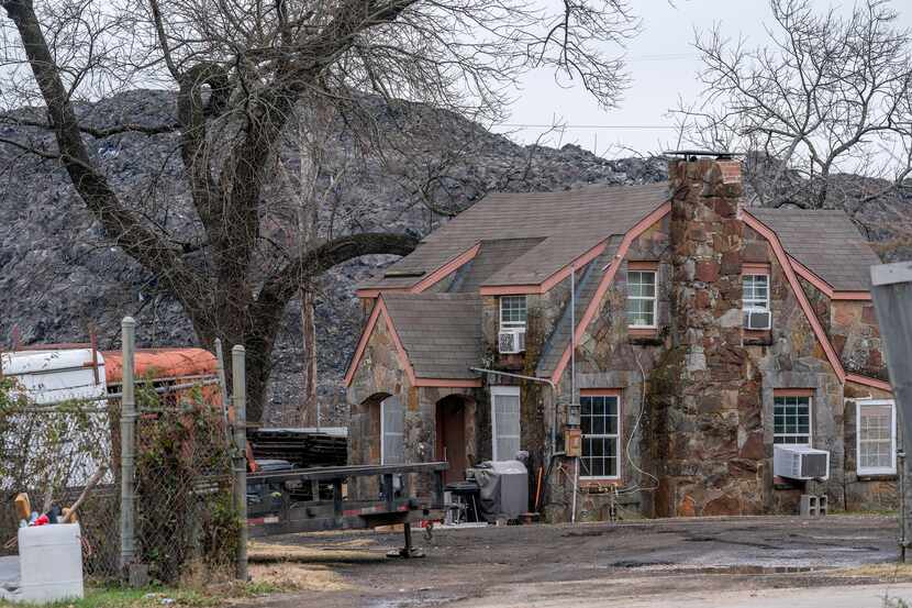 The pile of roofing shingles known as Shingle Mountain rises above a house in southern...