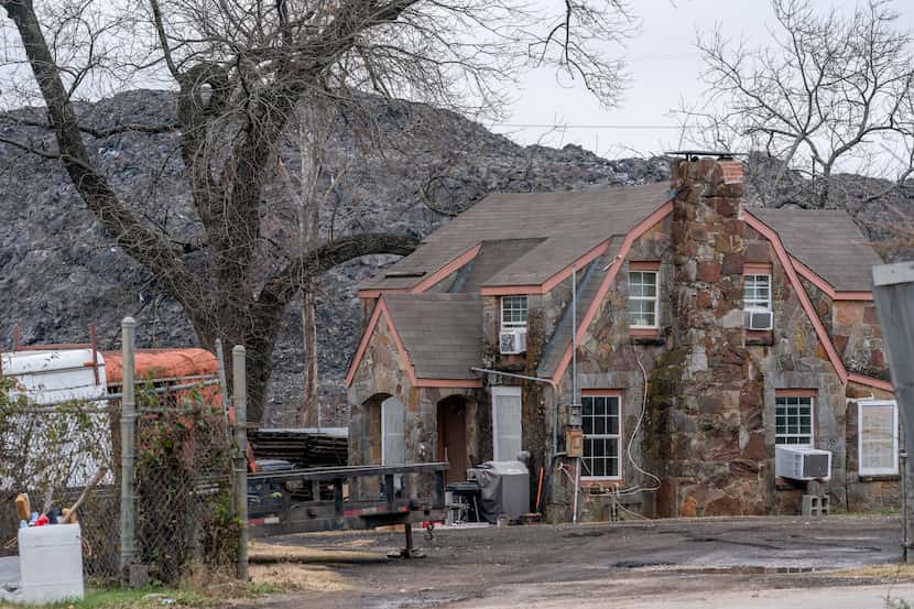 The pile of roofing shingles known as “Shingle Mountain” rises above a house, Tuesday,...