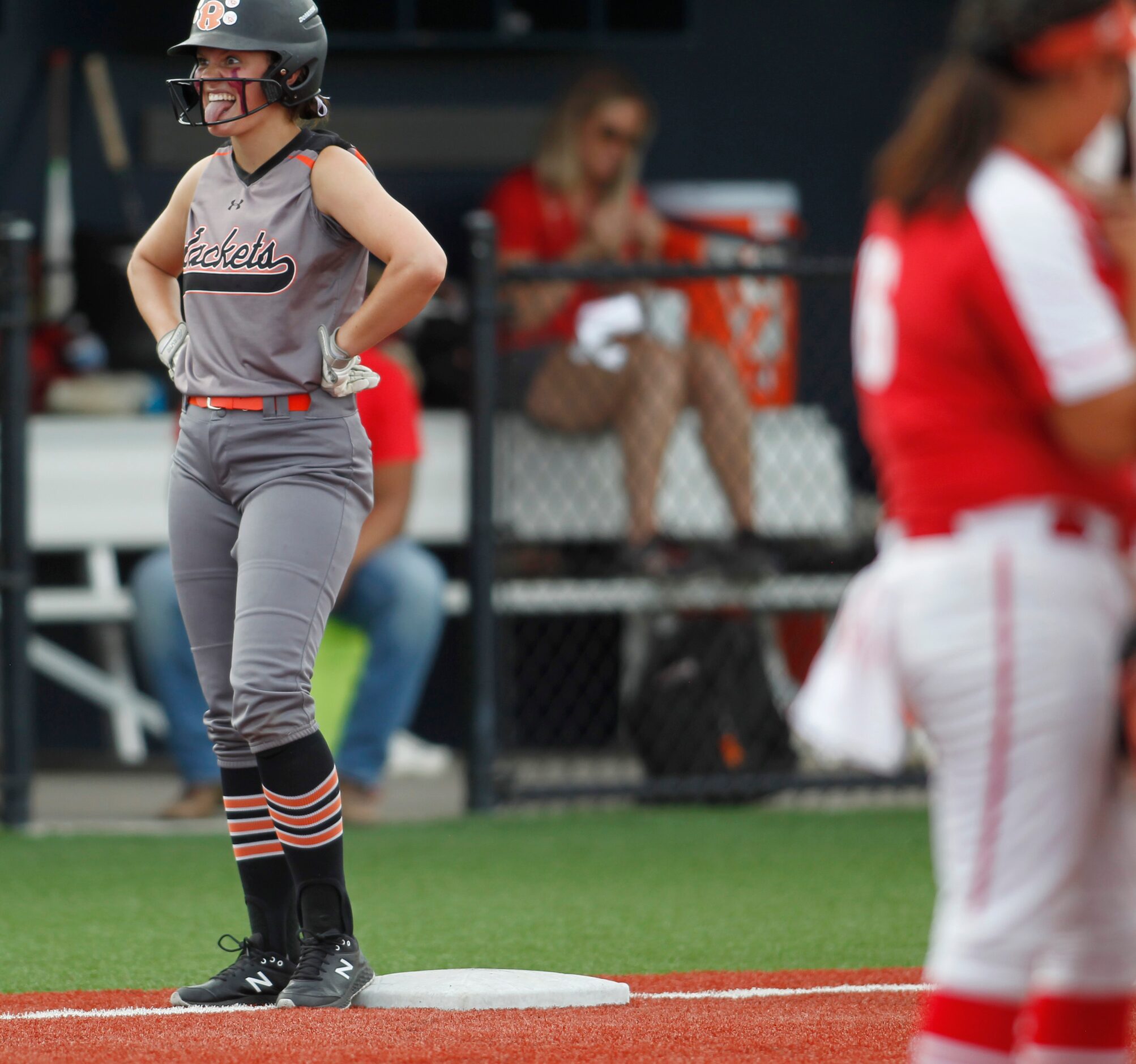 Rockwall outfielder Carter Smith (13) spends a light moment with a teammate after reaching...