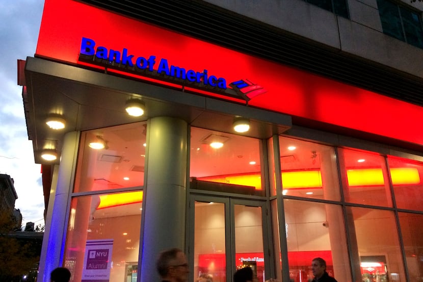 FILE- In this Nov. 6, 2017, file photo, people walk by a branch office of Bank of America in...