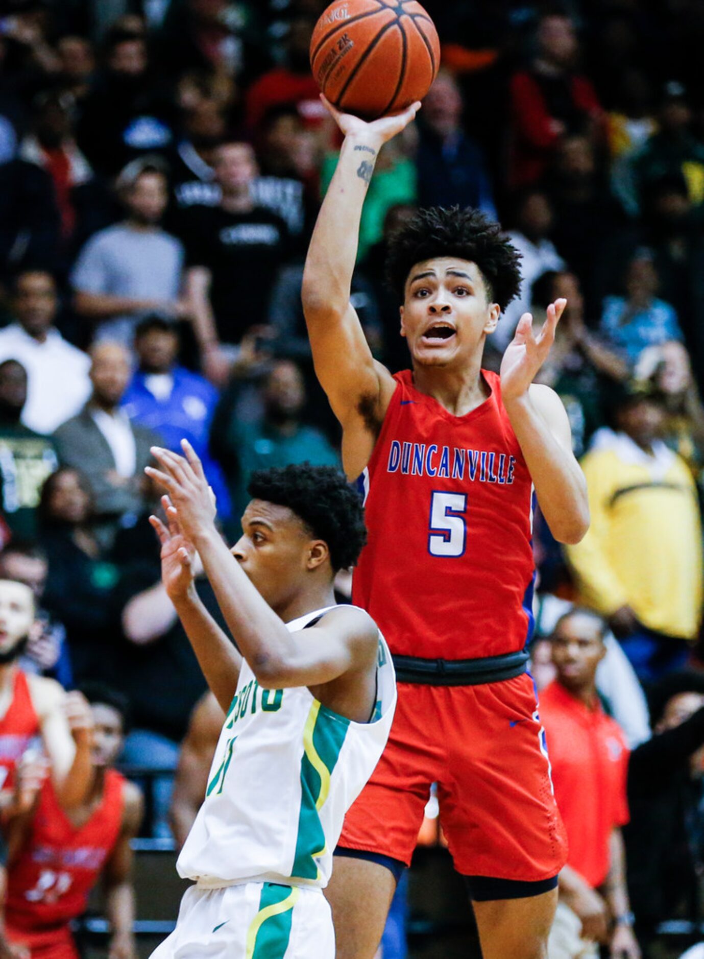 Duncanville junior guard Micah Peavy (5) attempts a shot as DeSoto senior guard Chris Pryor,...