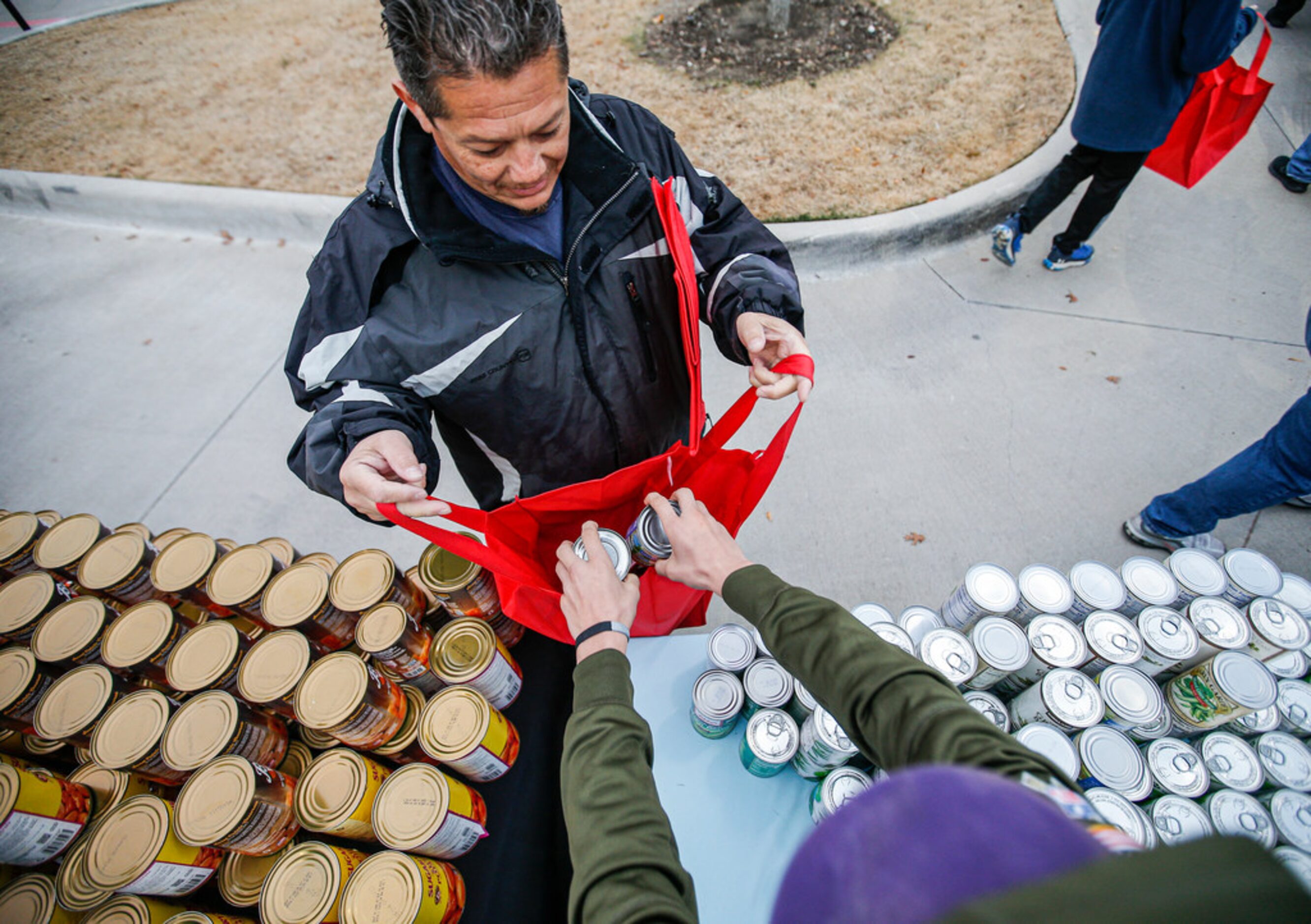 Brady Boozer, 12, places cans of green beans into Andy InocencioÃs bag at at the Texas...