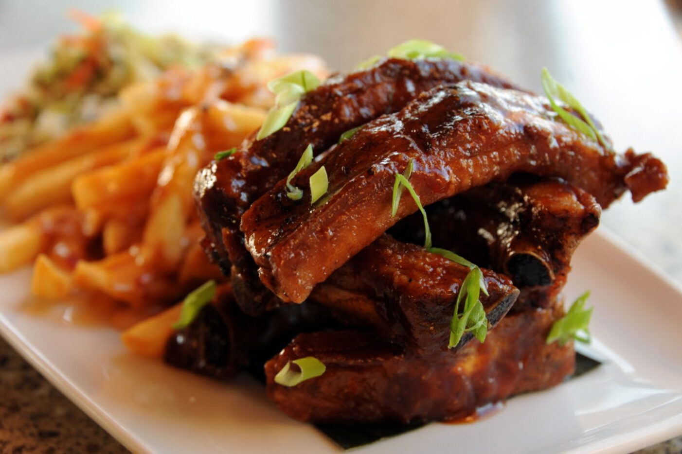 Hawaiian sticky ribs are tossed with house made BBQ sauce and are served with french fries...