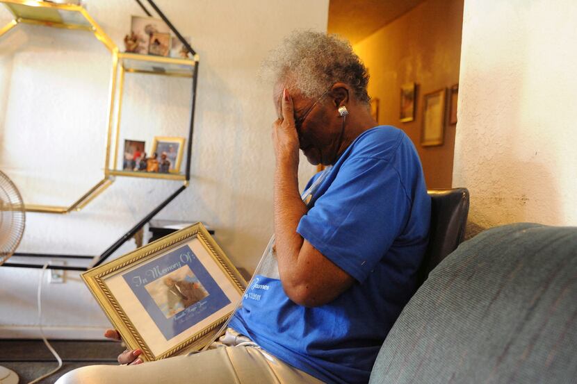 Mary Lou James cries as she looks at the photograph of her deceased son Kenneth Wayne James,...