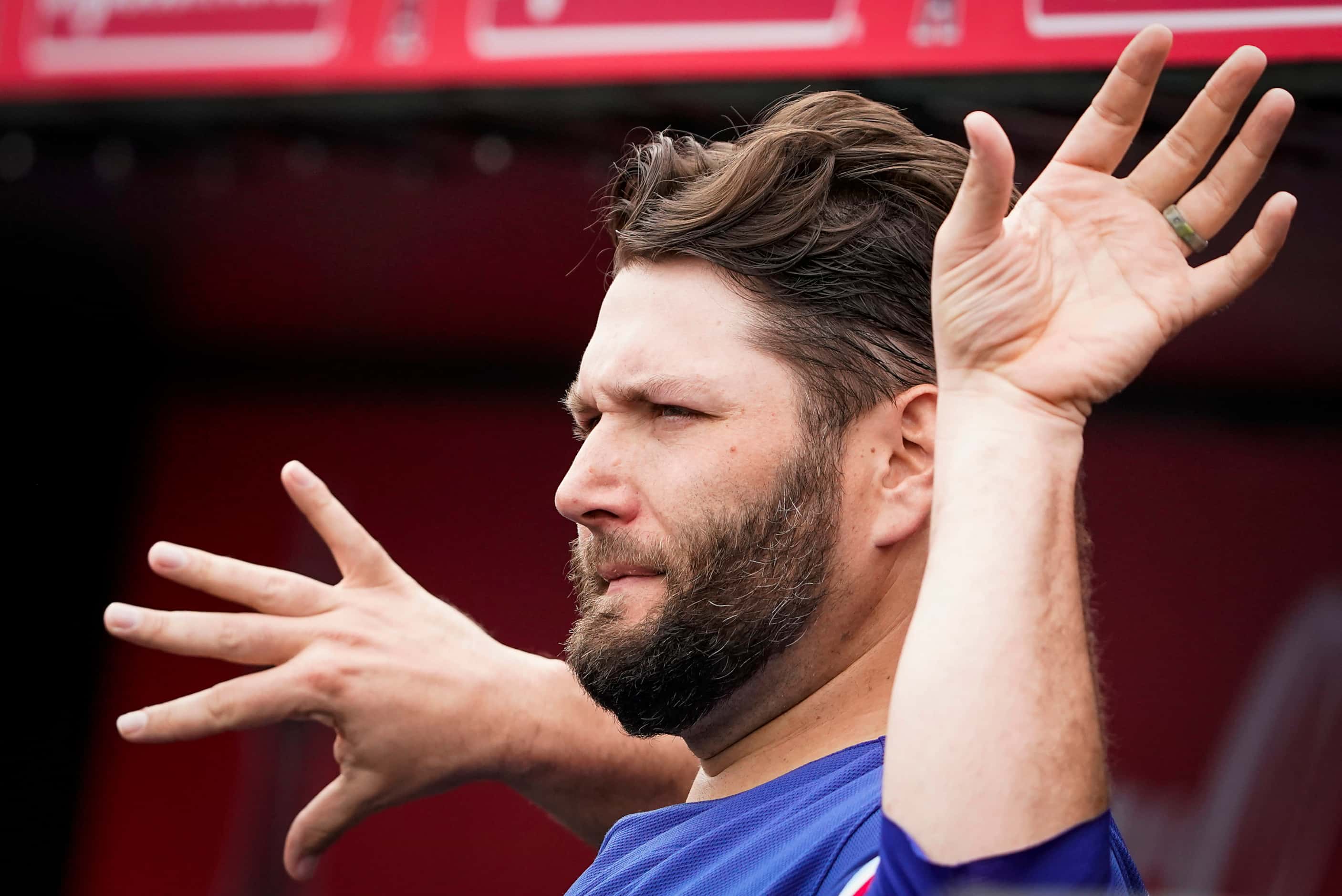 Texas Rangers pitcher Lance Lynn stretches in the dugout before a spring training game...