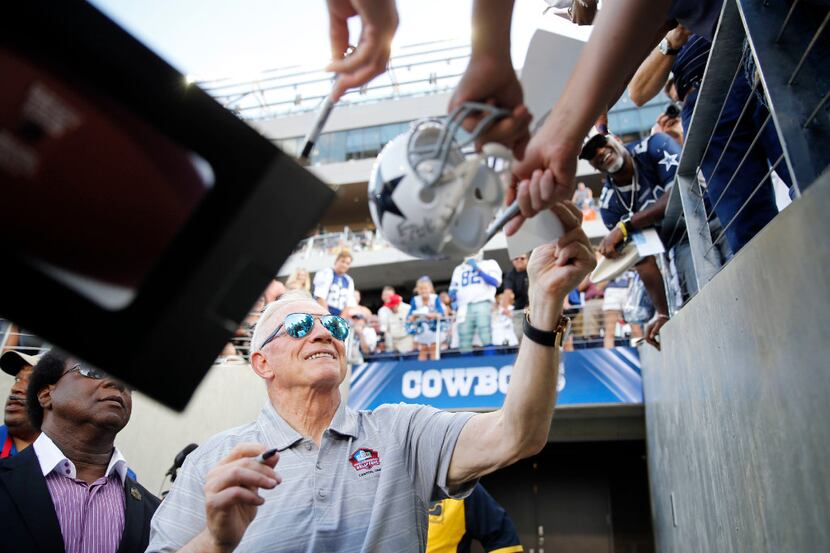 Dallas Cowboys owner and general manager Jerry Jones gives out his autograph to fans before...