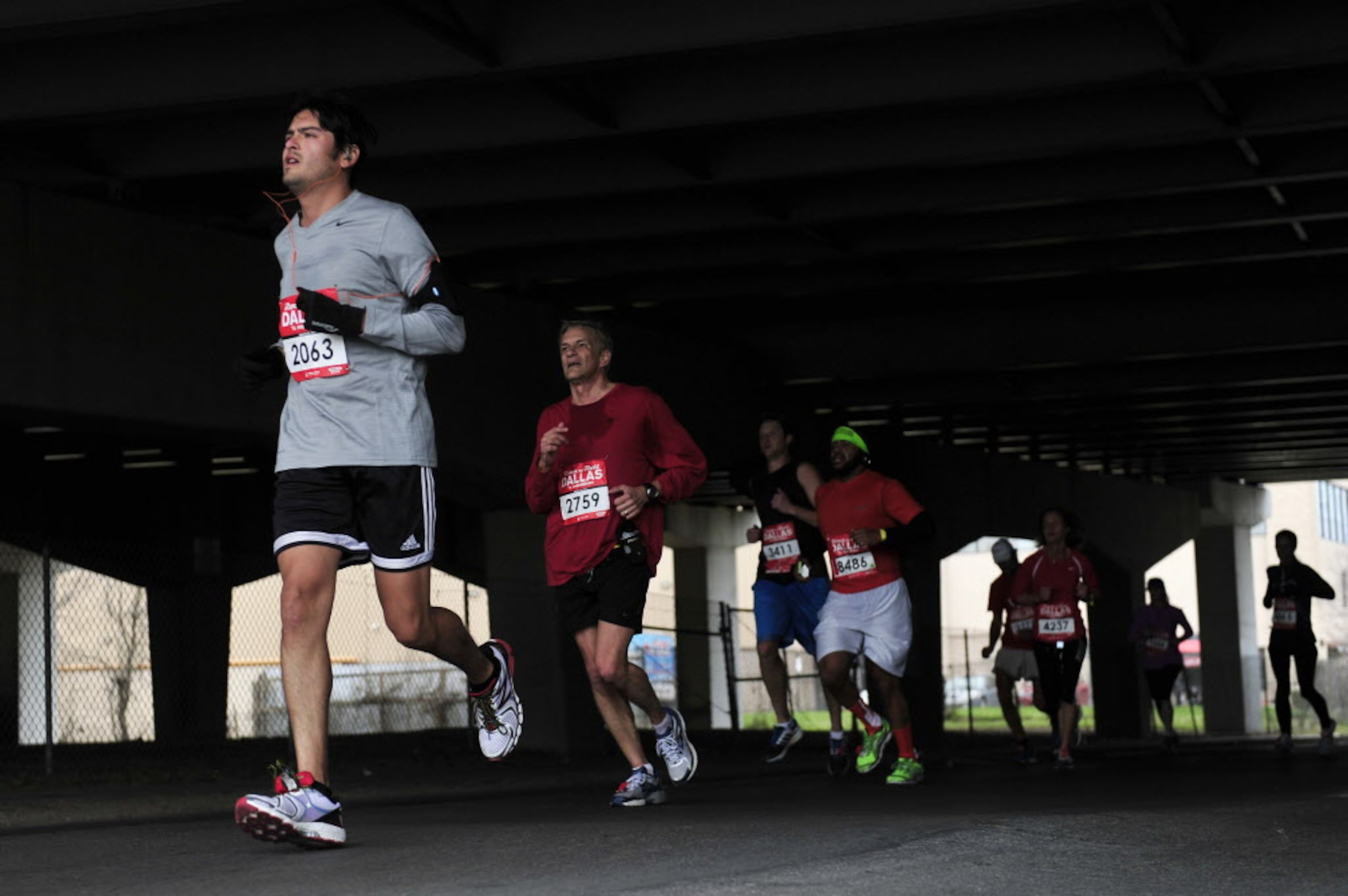 Runners go under a bridge near the last water stop during the Dallas Rock N' Roll...