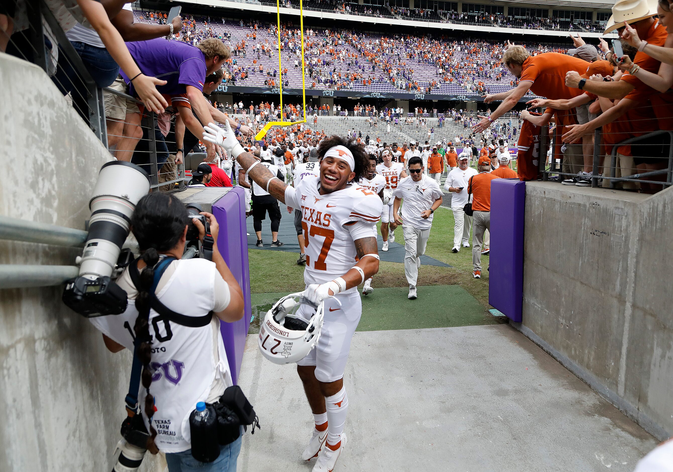 Texas Longhorns defensive back JD Coffey III (27) celebrates with fans while heading into...