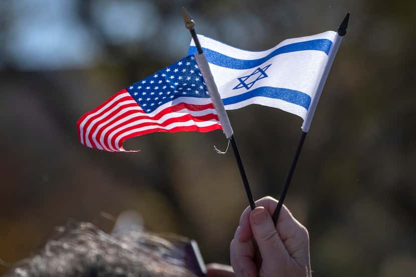 A participant holds miniature U.S. and Israeli flags as they stand on the National Mall at...