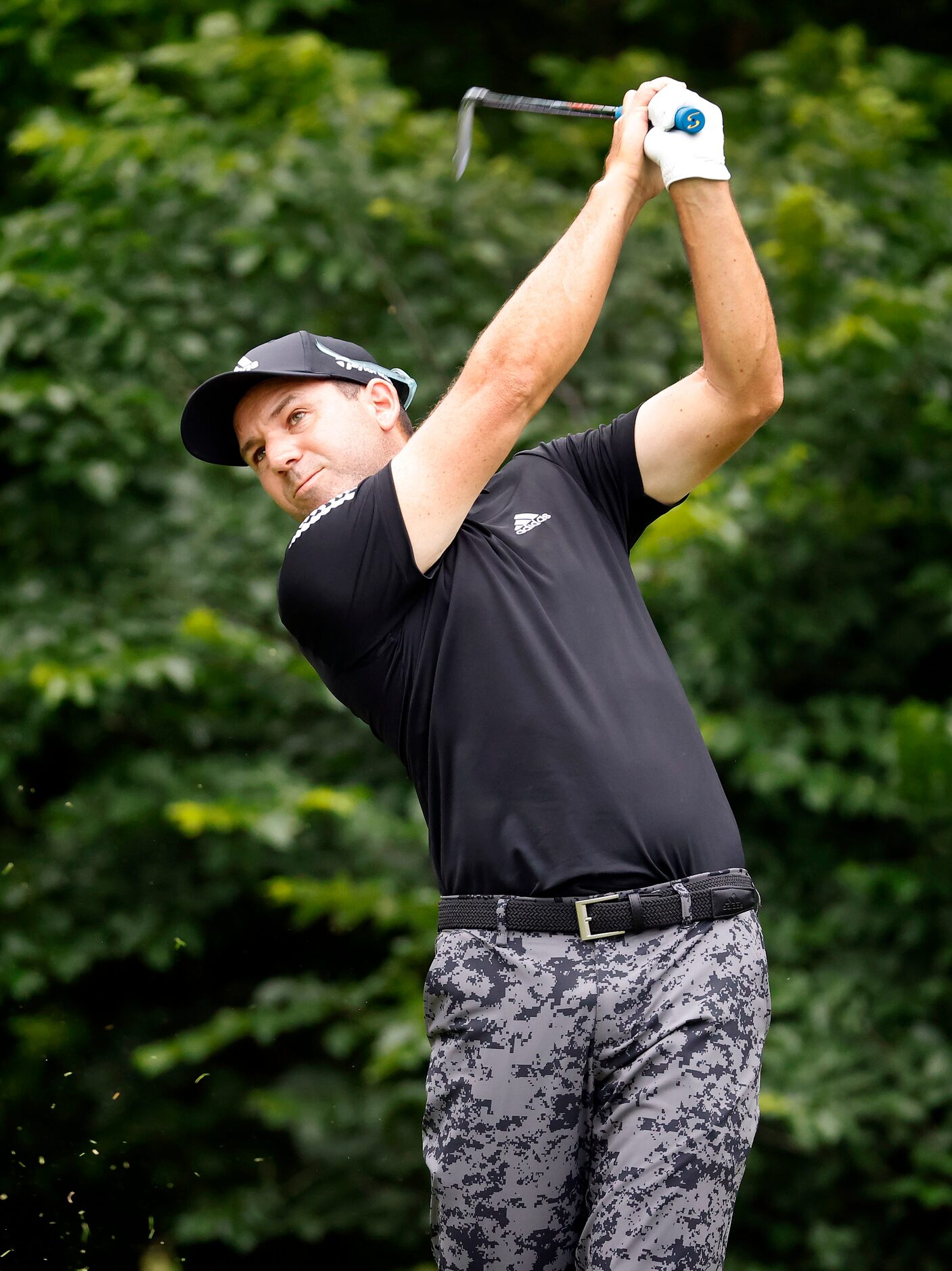 Professional golfer Sergio Garcia follows through on his tee shot on the par-3, No. 8 during...