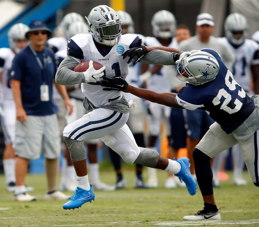 Dallas Cowboys rookie running back Ezekiel Elliott (21) gives a stiff arm to Dallas Cowboys...