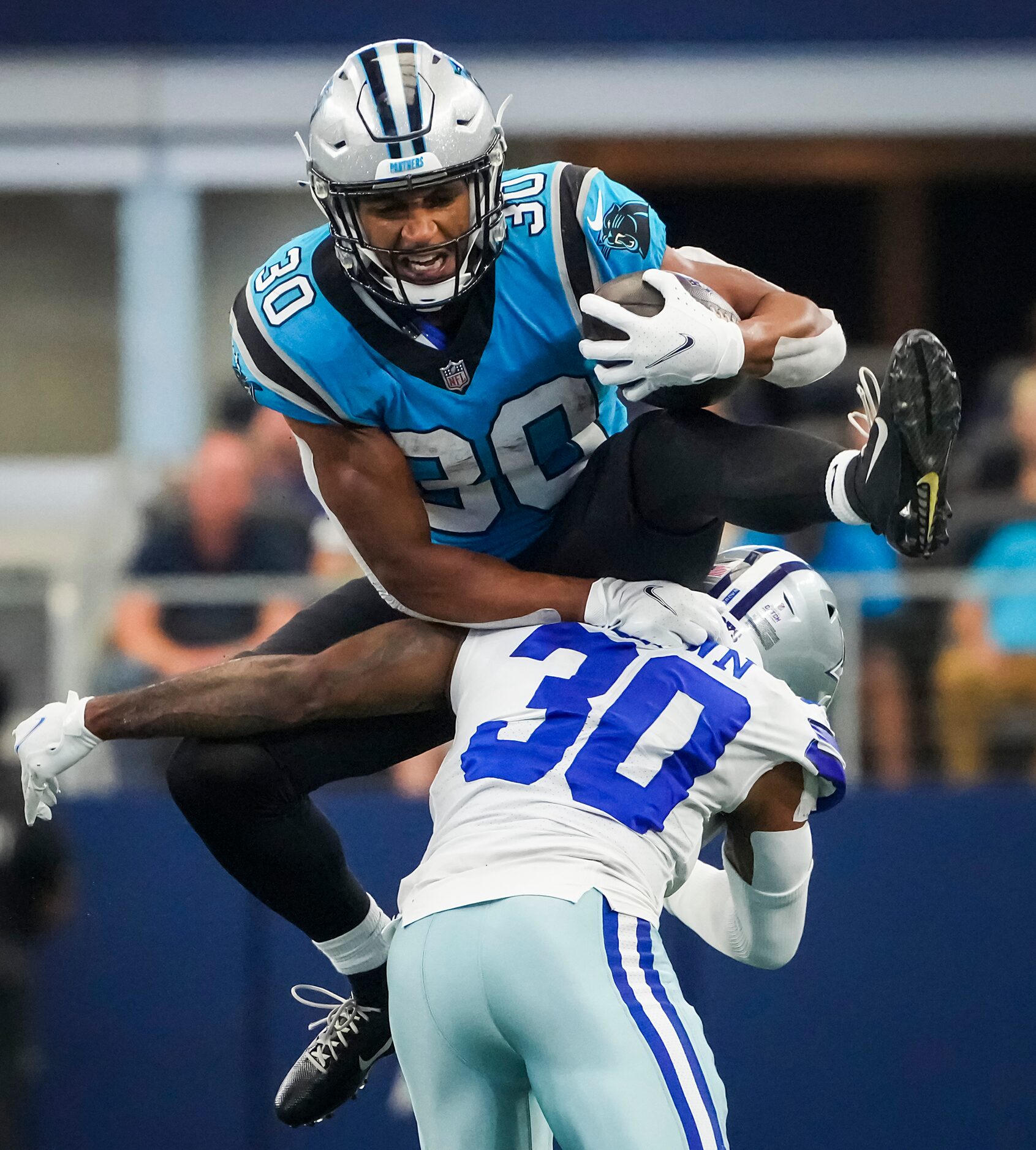 Carolina Panthers running back Chuba Hubbard  tries to hurdle Dallas Cowboys cornerback...