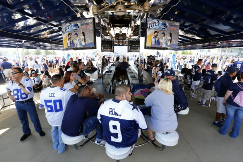 Cowboy fans hang out in an outdoor bar on the east plaza before the Dallas Cowboys met the...