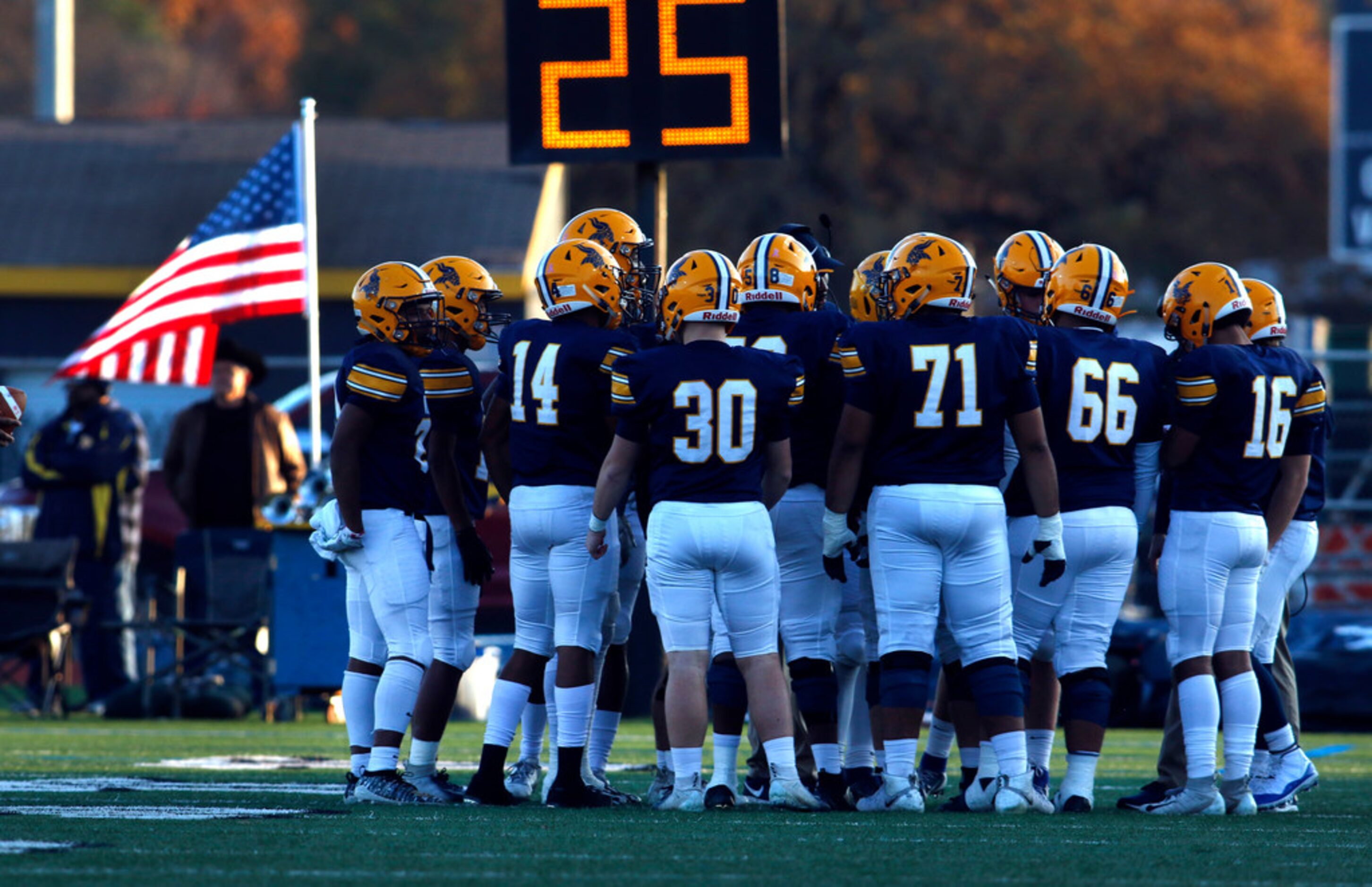 Members of the Arlington Lamar Vikings pause for a timeout along the team bench area during...