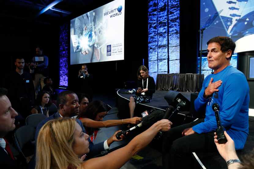 Dallas Mavericks owner Mark Cuban, right, answers question from the media about honoring the...