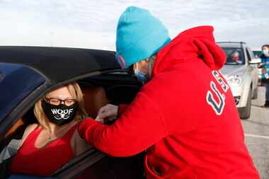 Sally Pratt of Denton gets bandage after receiving a COVID-19 vaccine shot from Penny Mayo,...