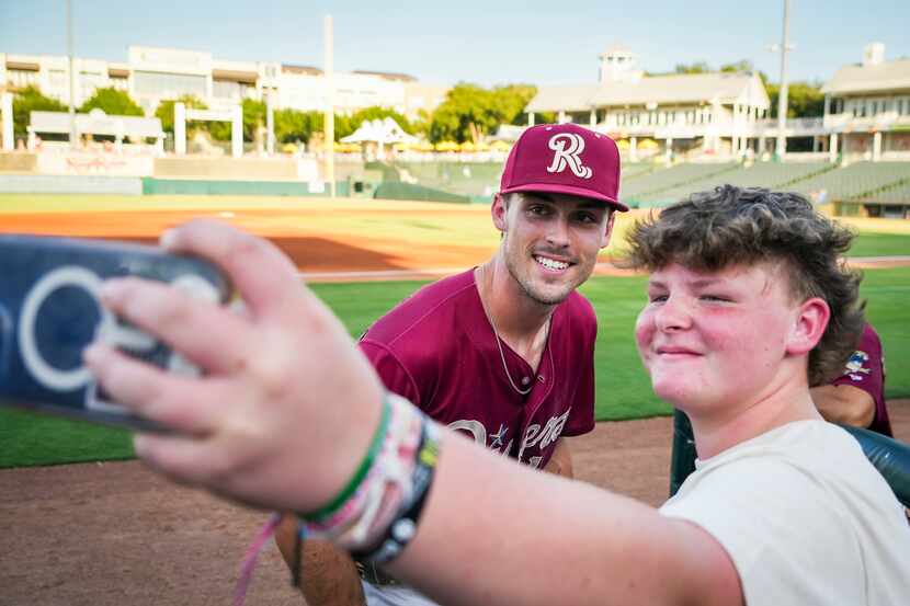 Frisco RoughRiders outfielder Evan Carter takes a photo with a fan before a Minor League...