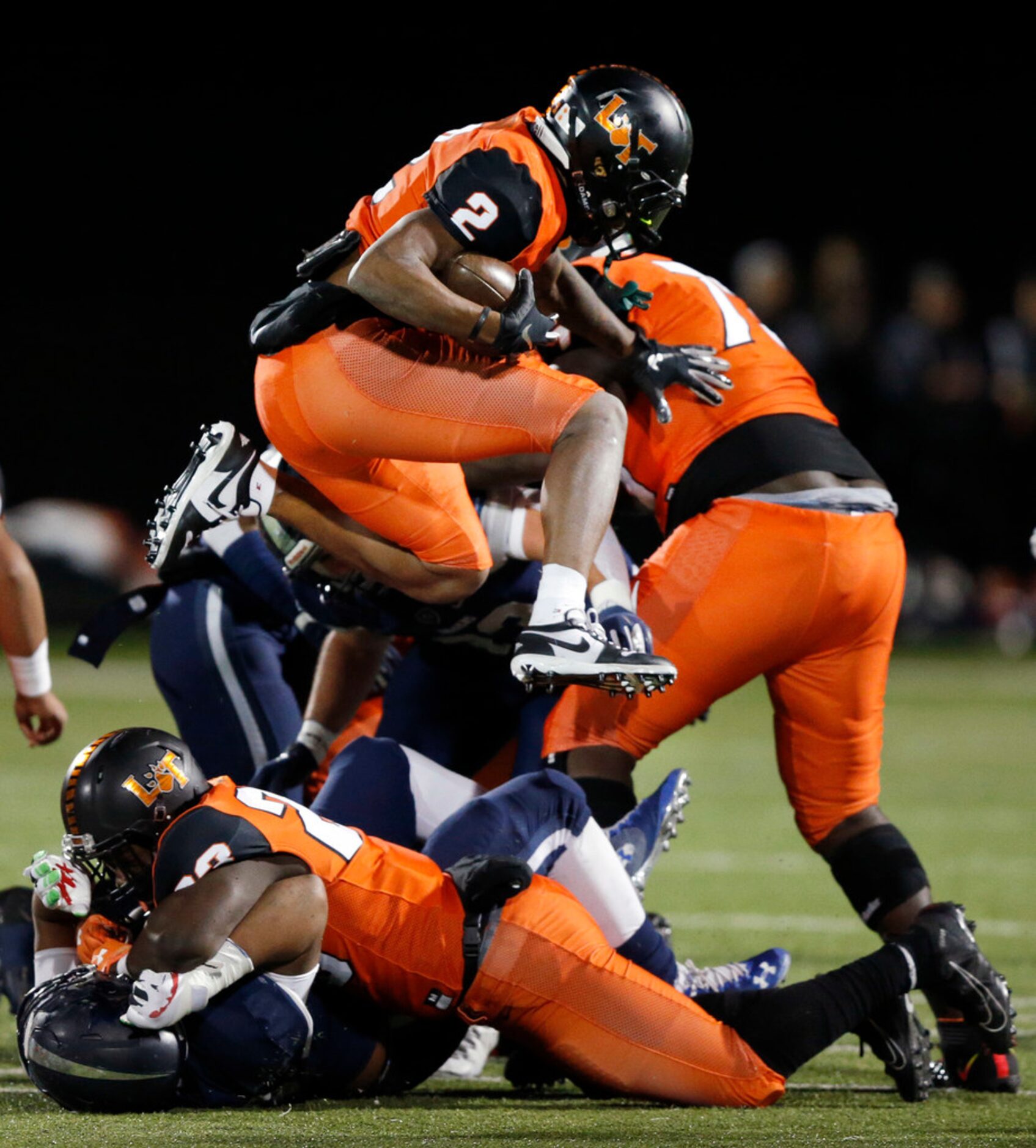 Lancaster running back Tre Bradford (2) hurdles a teammate in the first quarter against...