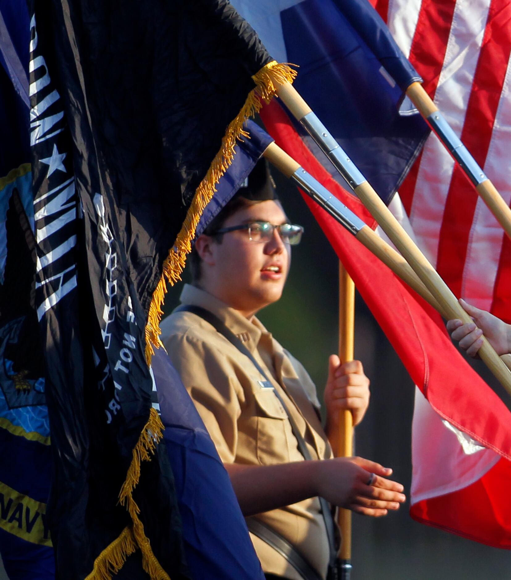 Red Oak commanding officer Joshua Tarver of the Jr. ROTC members is framed by flags prior to...