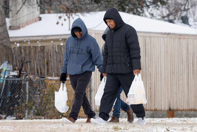 Werner Choc, 26, and Saul Ruiz, 36, walk with groceries along Esperanza Road on Friday in...