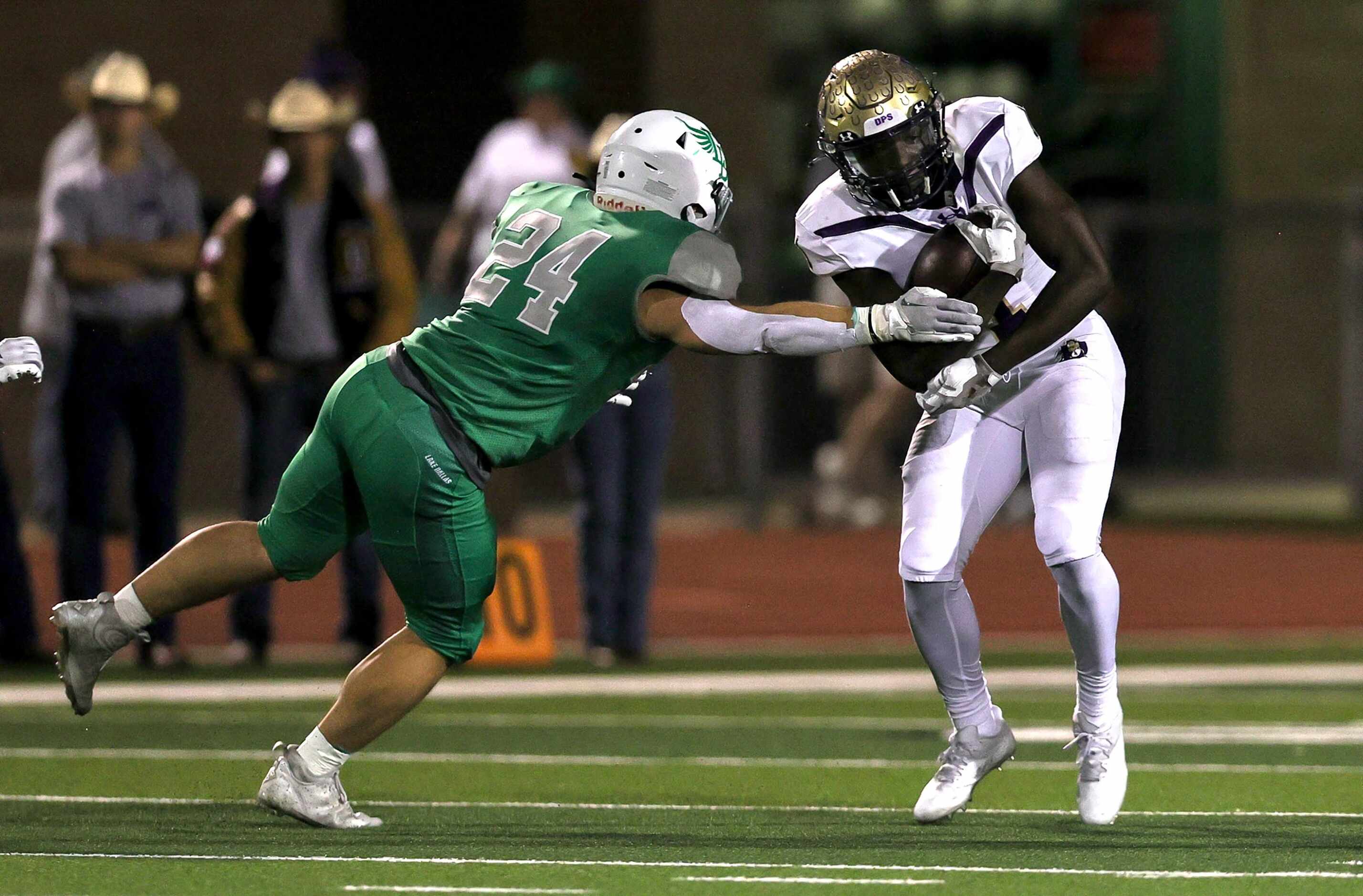 Denton running back Coco Brown (right) tries to avoid Lake Dallas linebacker Riley Griffin...