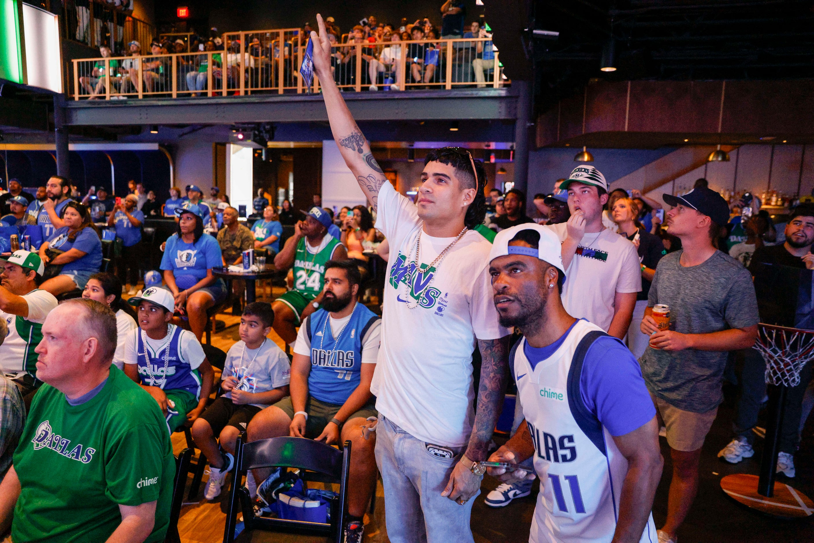 Dallas Mavericks fans Jacob Johnson (right) and Josh Espinosa (second from right) react...