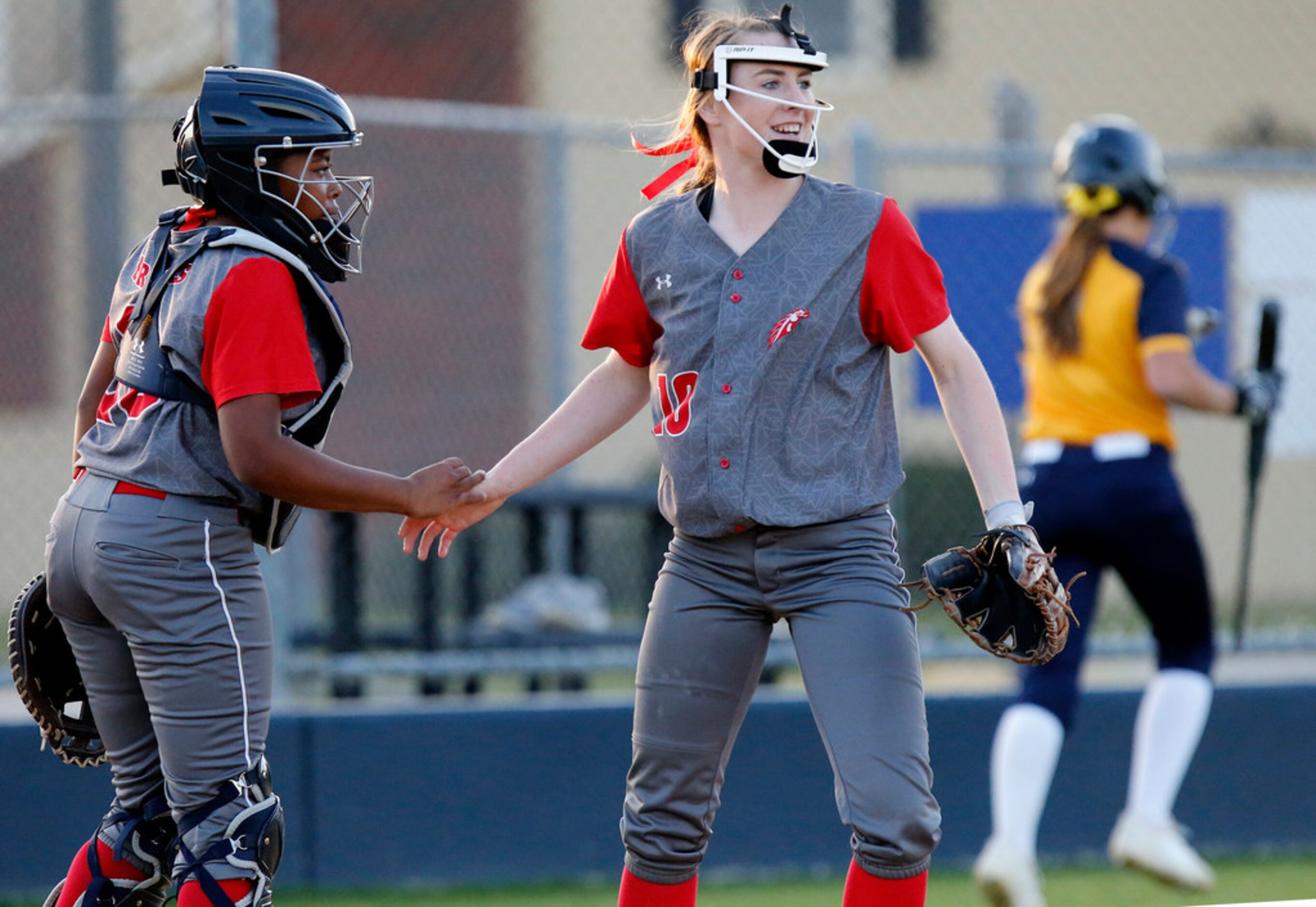 McKinney Boyd High School pitcher Kinsey Kackley (10) is congratulated by McKinney Boyd High...