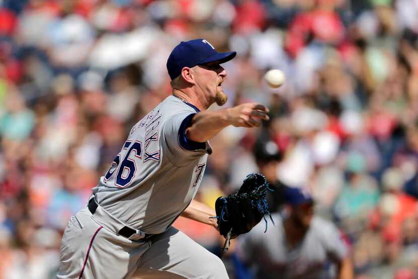 Texas Rangers starting pitcher Austin Bibens-Dirkx throws during the first inning of a...